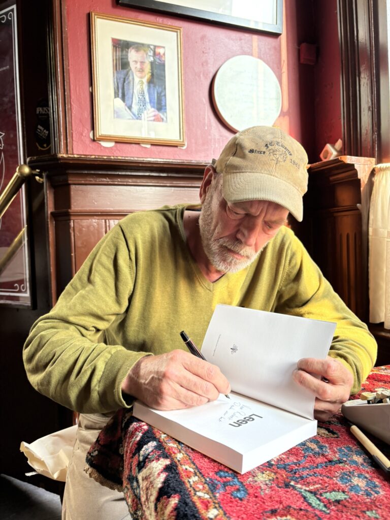 Willy Berends signeert 'Leen', de nieuwe biografie over Leendert Overduin, in café het Bolwerk in Enschede.